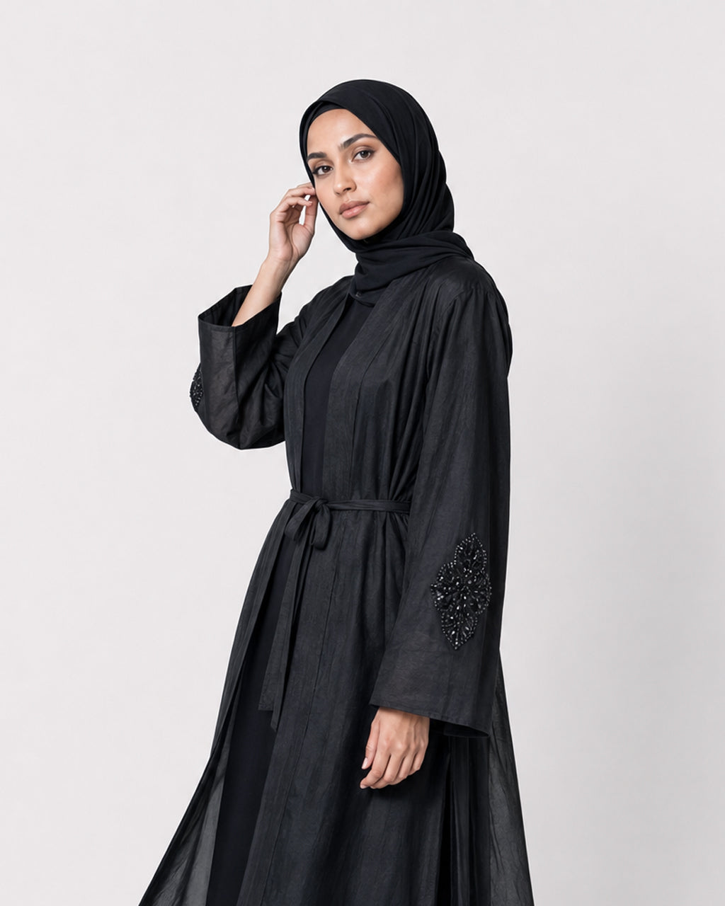 Black silk cotton Persia jacket with handcrafted embellishment, worn open over a matching black slip dress.