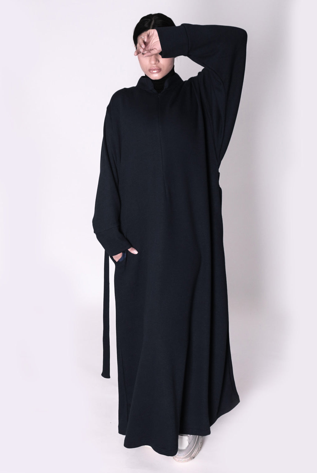 Person wearing a black abaya on a white background