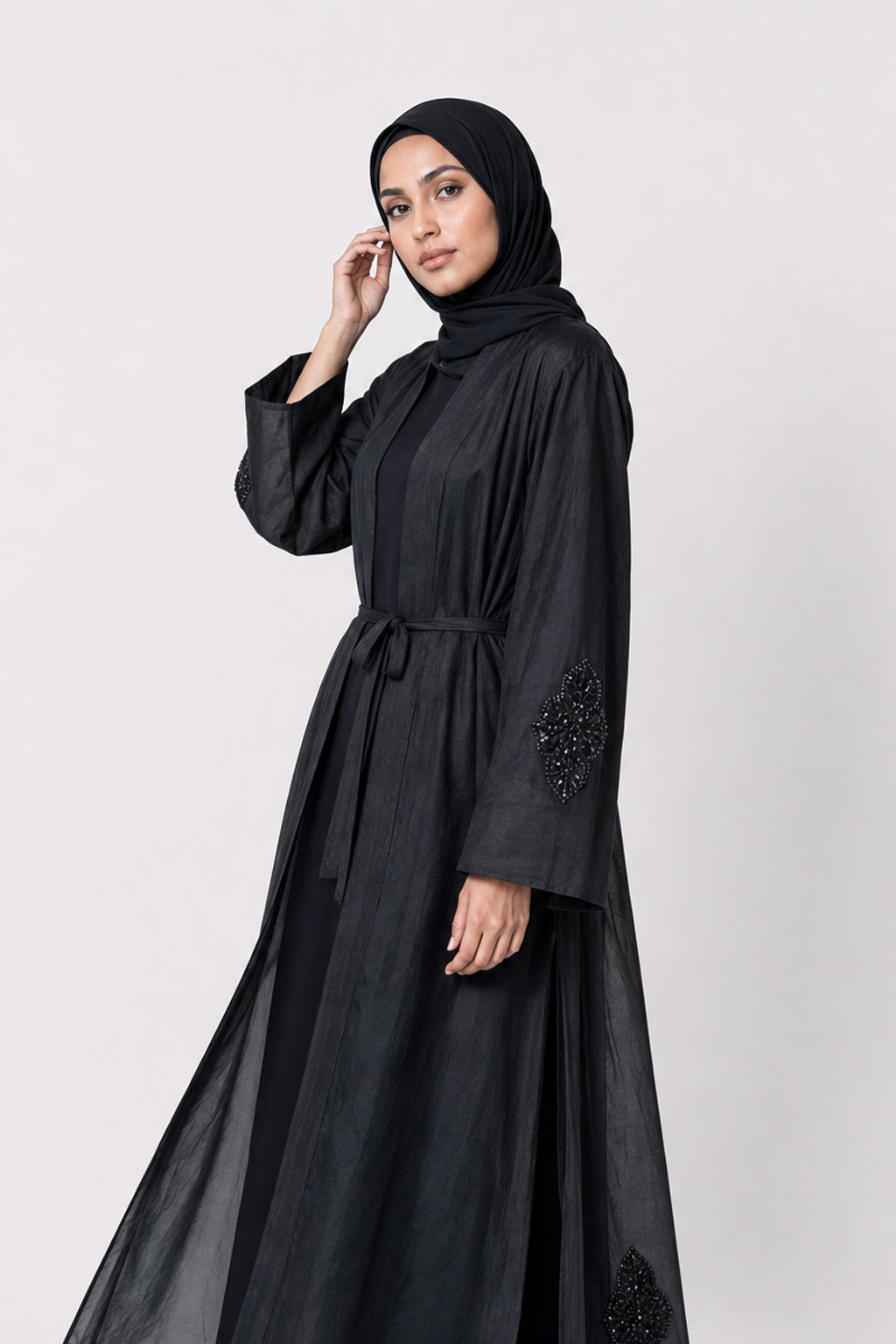 Black silk cotton Persia jacket with handcrafted embellishment, worn open over a matching black slip dress.