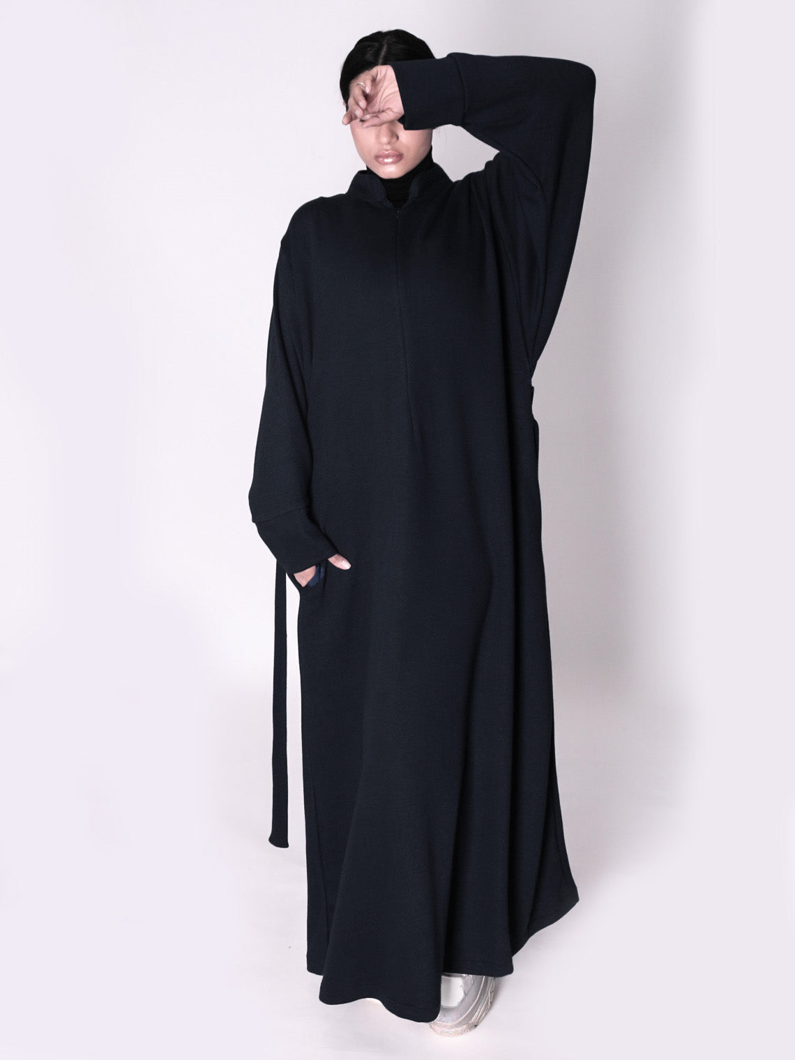 Person wearing a black abaya on a white background