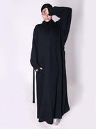 Person wearing a black abaya on a white background
