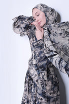 A woman wearing a Kyoto print hijab with a floral pattern in shades of gray and blue.