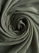 Rolled-up green fabric with a textured surface. olive modal hijab