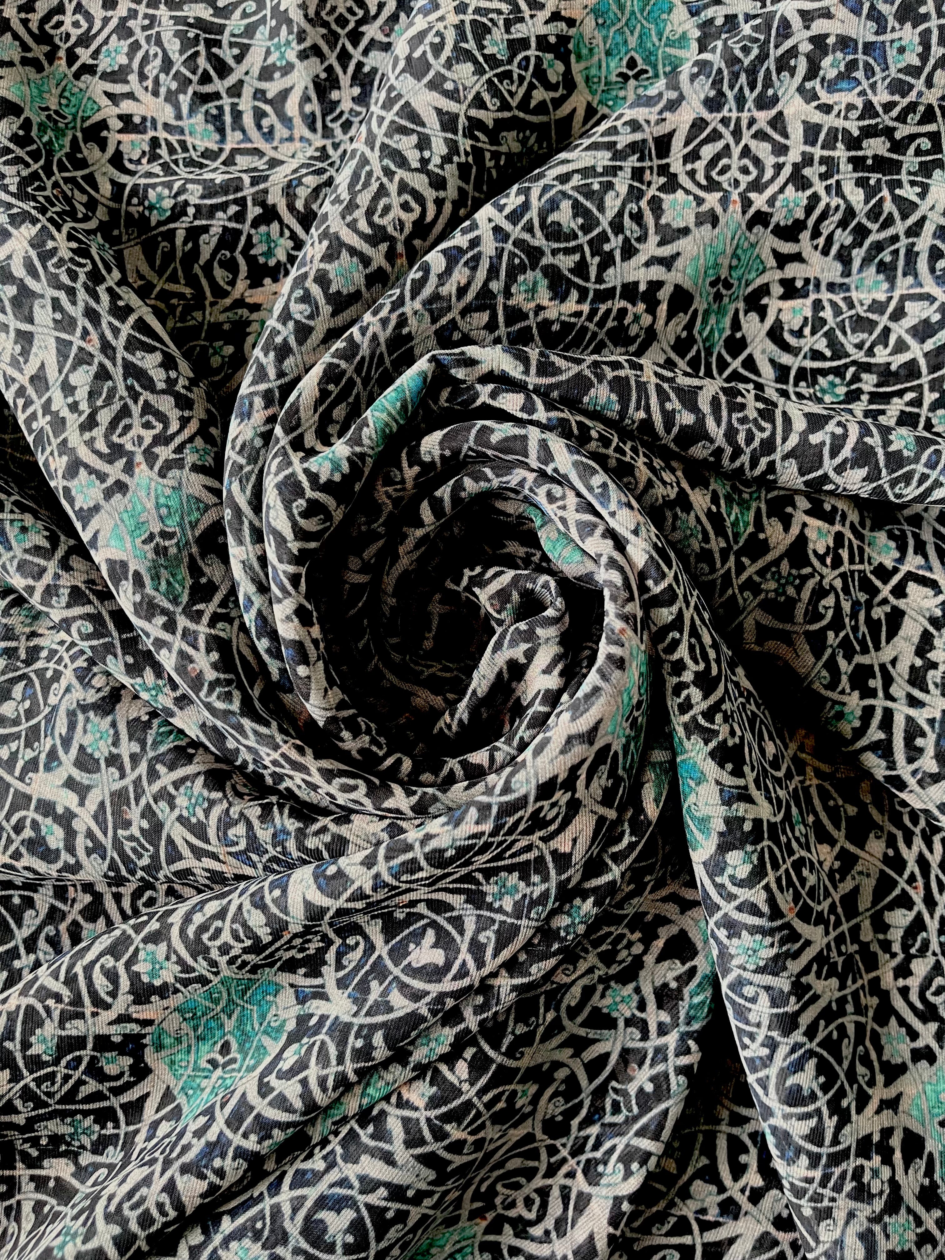 A close-up view of a blue and white swirl print hijab, showcasing the delicate pattern and fabric texture.